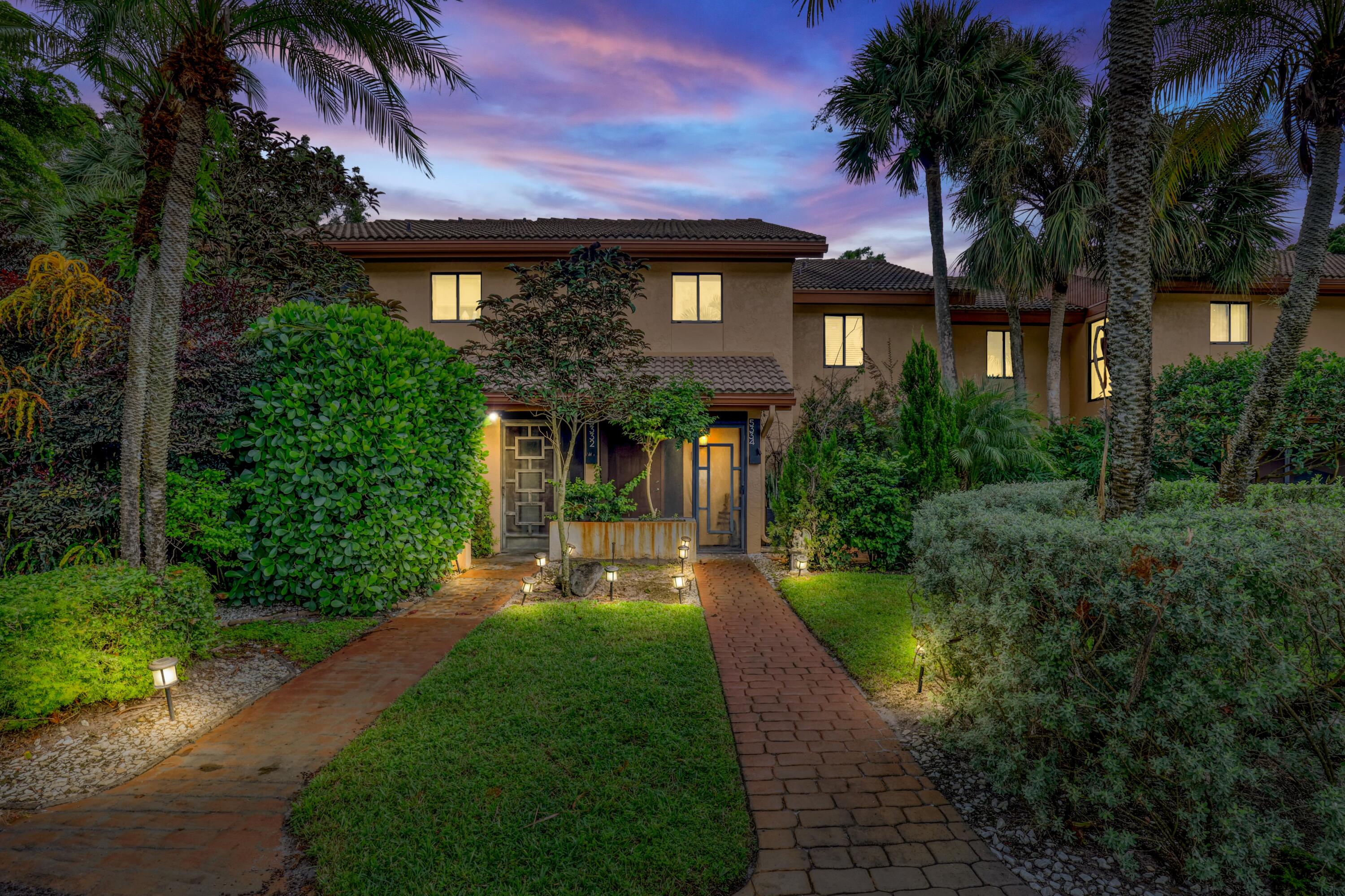 a front view of a house with yard and green space