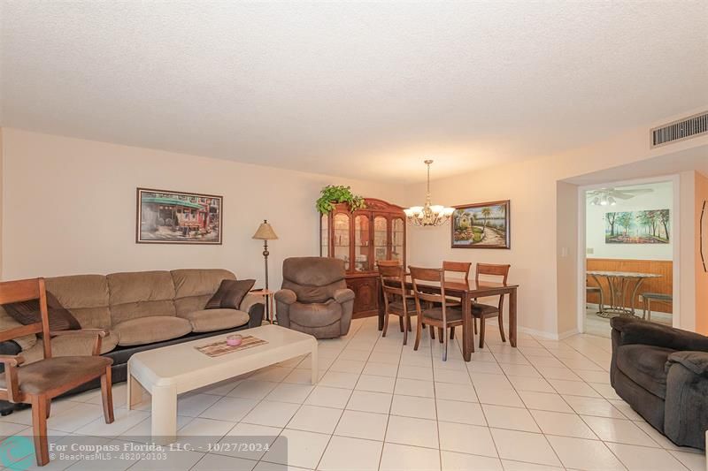 a living room with furniture and a dining table with chair