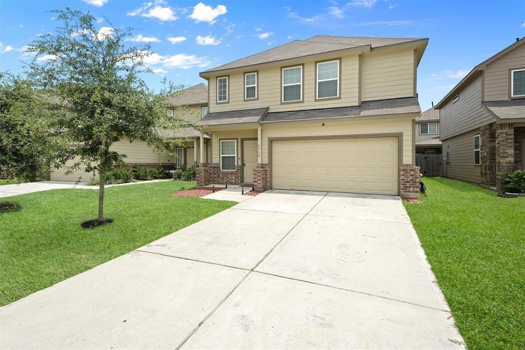 a front view of a house with a yard and trees