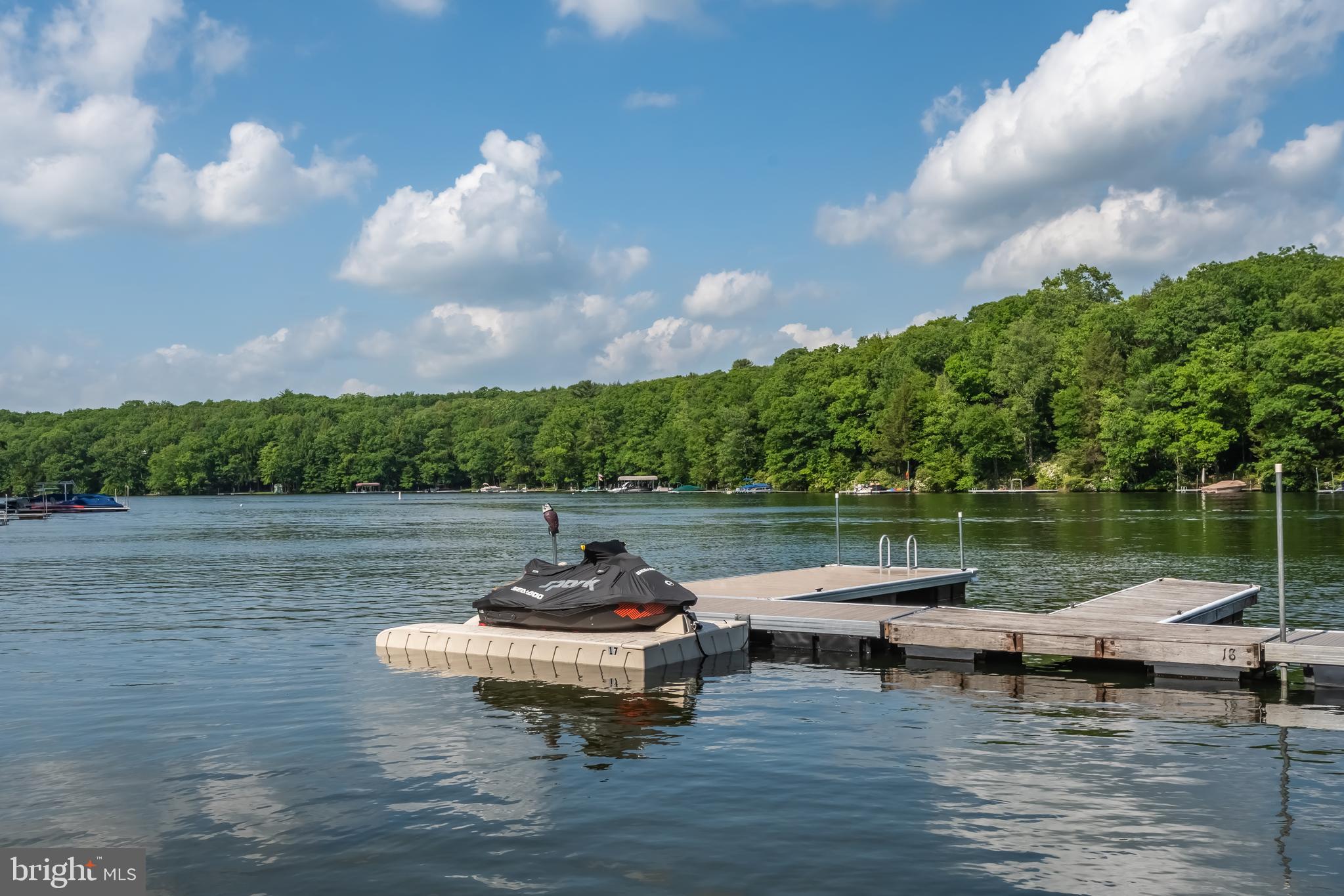 a view of a lake with lawn chairs and a table