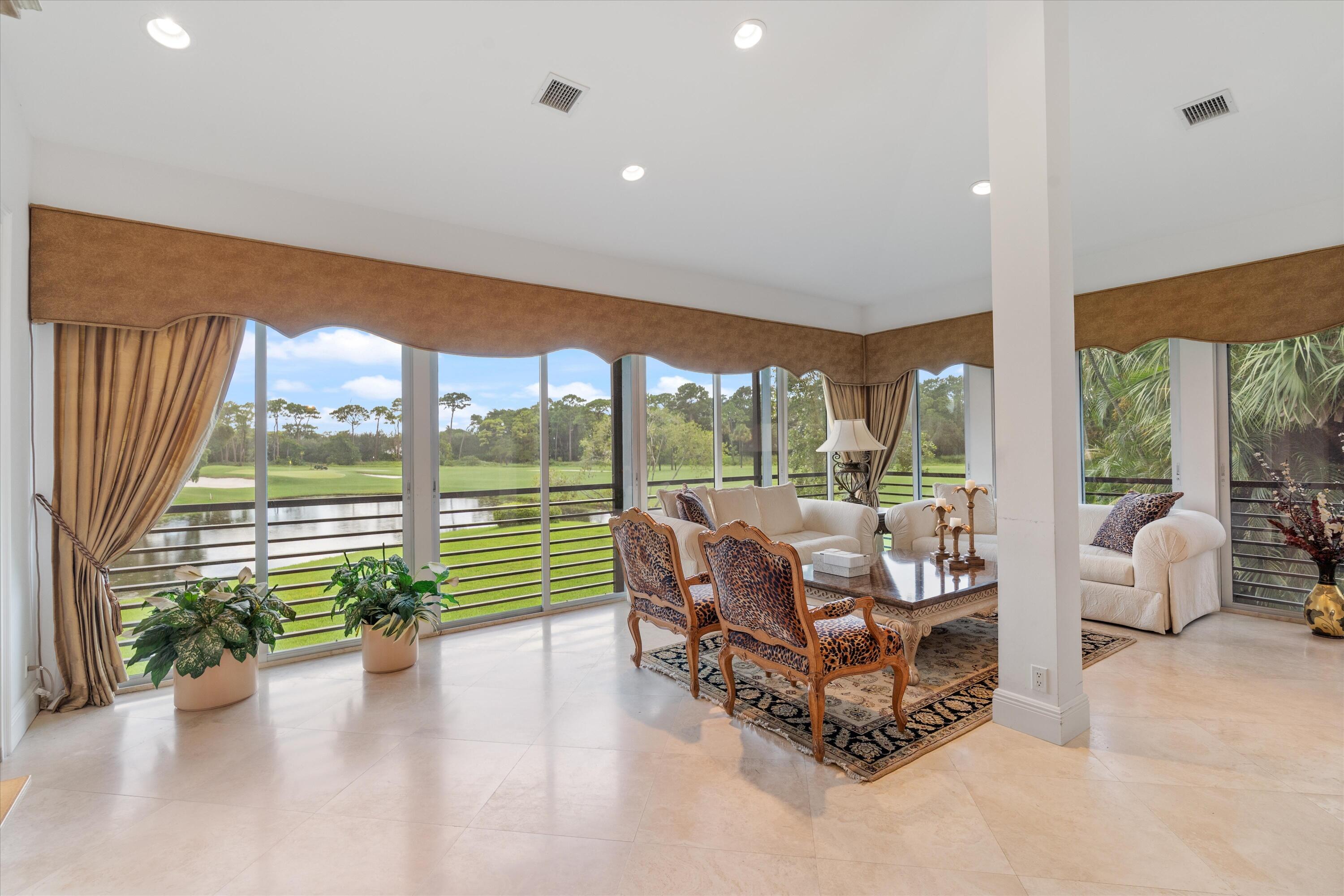 a living room with furniture and floor to ceiling window