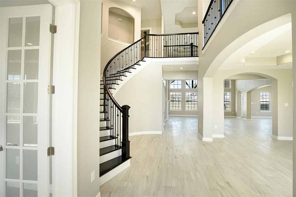 a view of an entryway with wooden floor leading to a furnished livingroom and windows