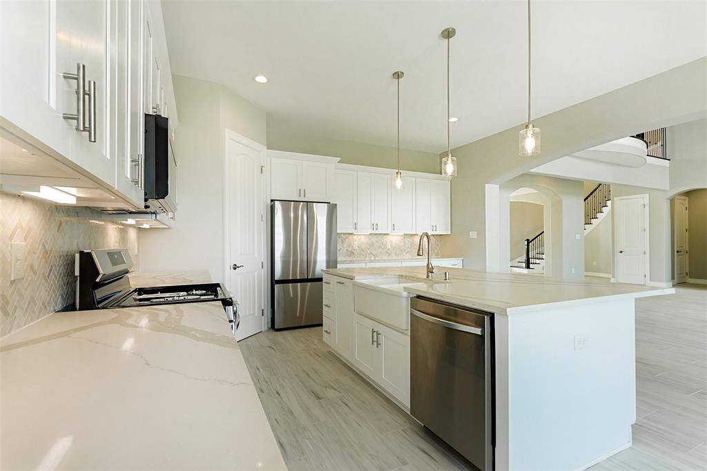 a kitchen with a sink a counter top space stainless steel appliances and cabinets