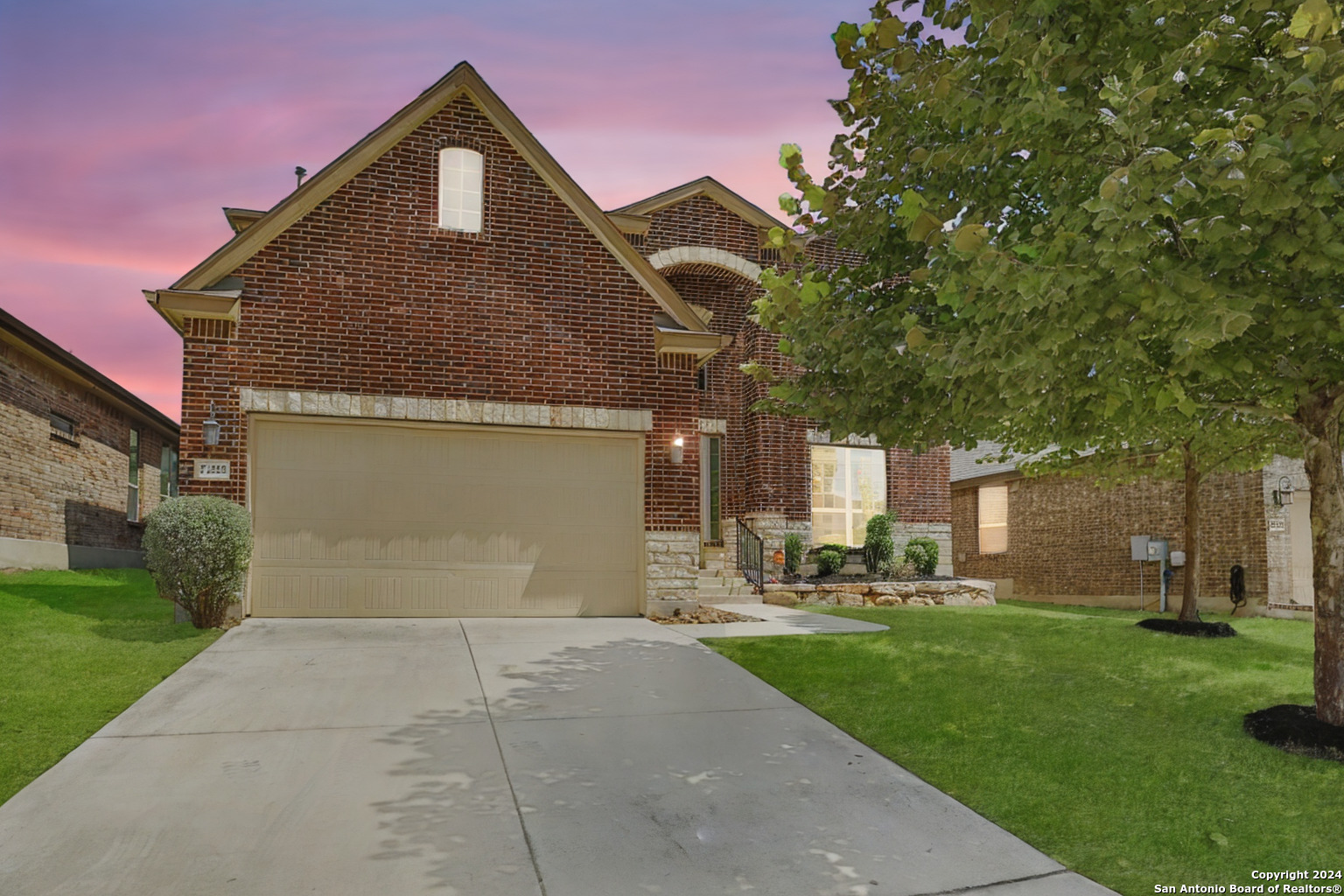 a front view of a house with a yard and trees