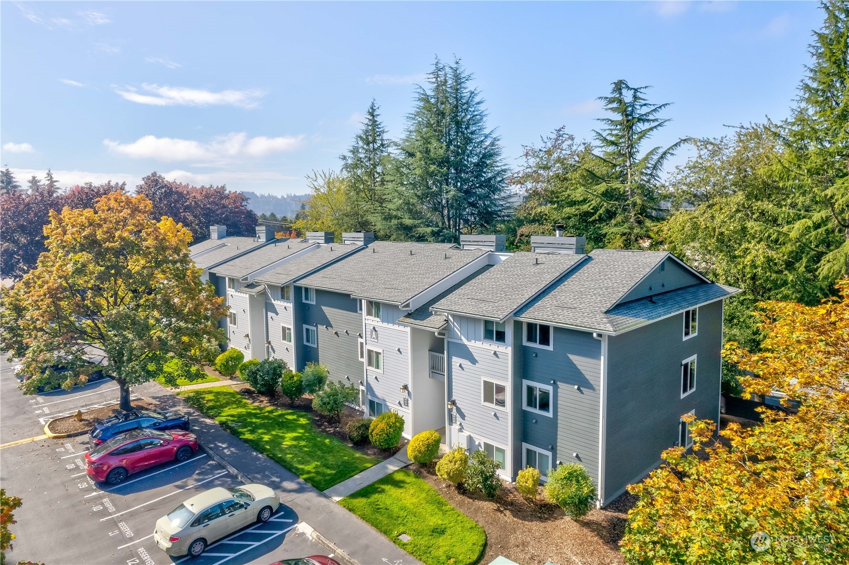 a aerial view of a house with yard and trees in the background