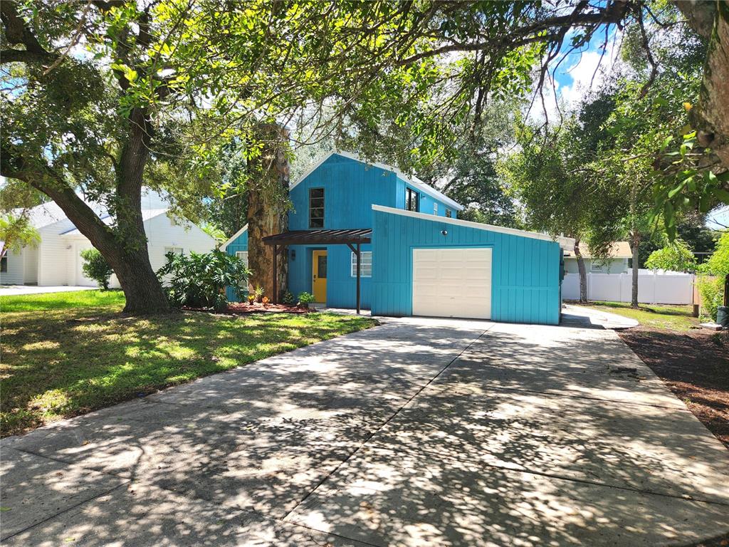 a front view of a house with a yard and tree