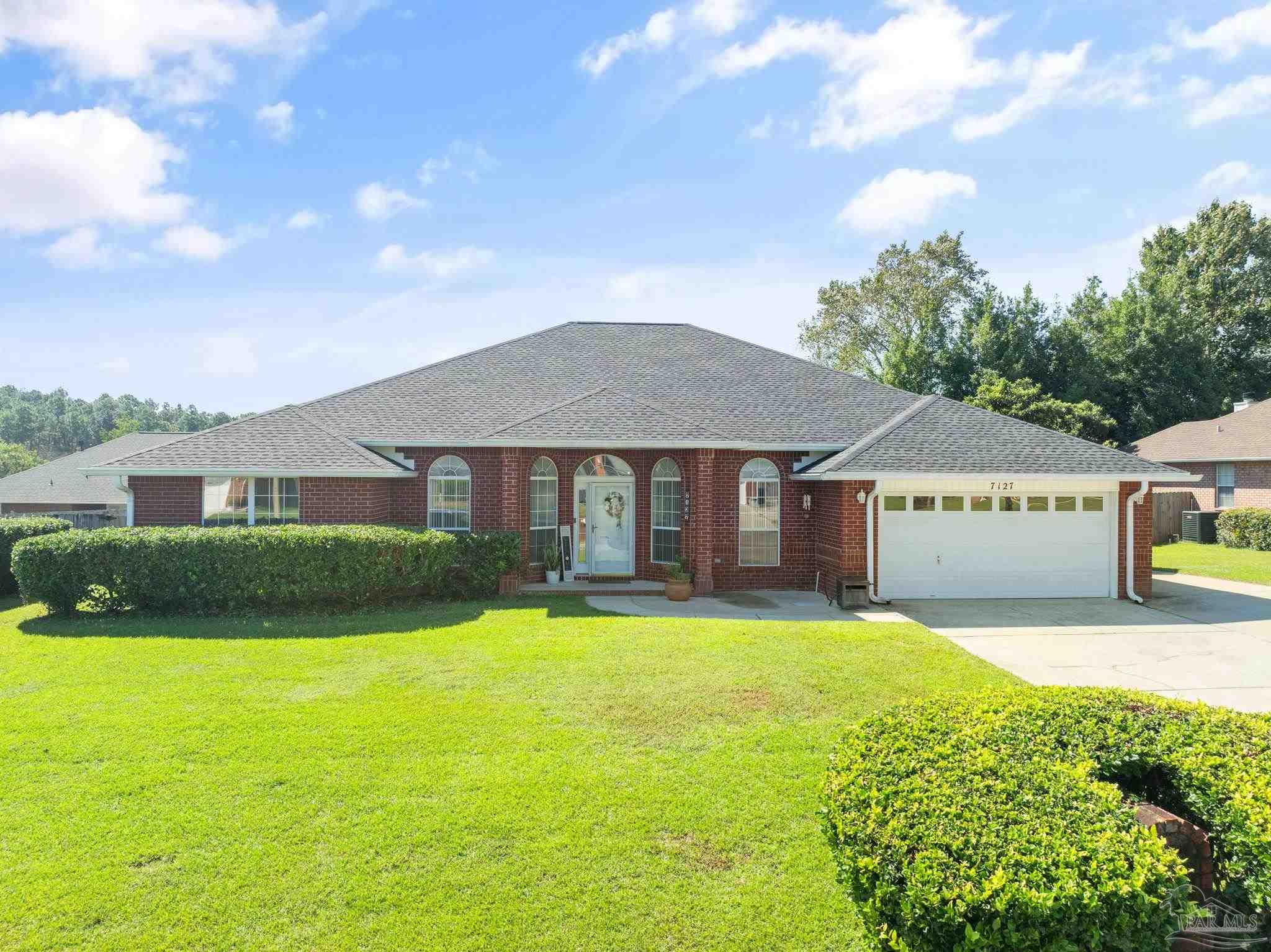 a front view of a house with yard and green space