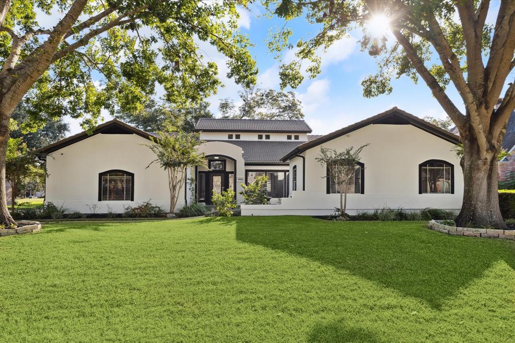 Beautiful single-story house with a white stucco exterior and dark trim!