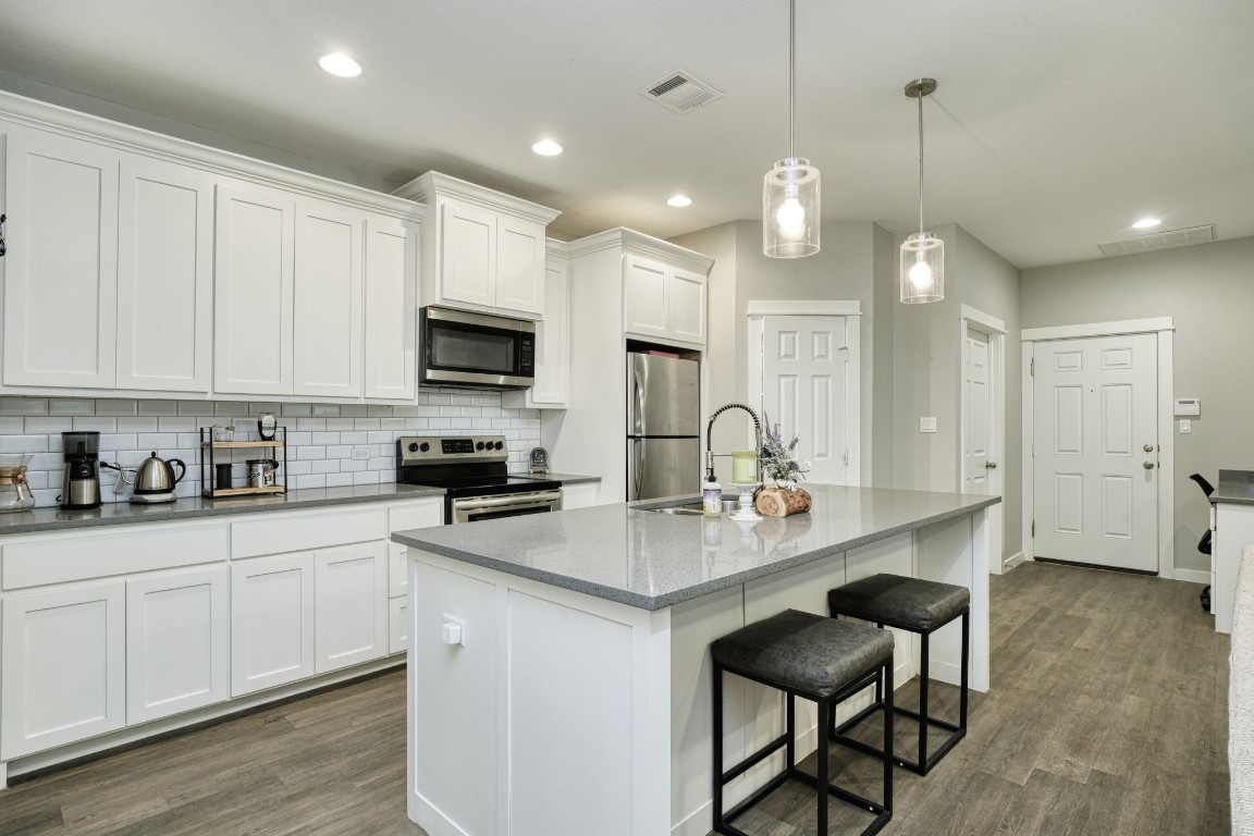 a kitchen with sink a microwave and cabinets