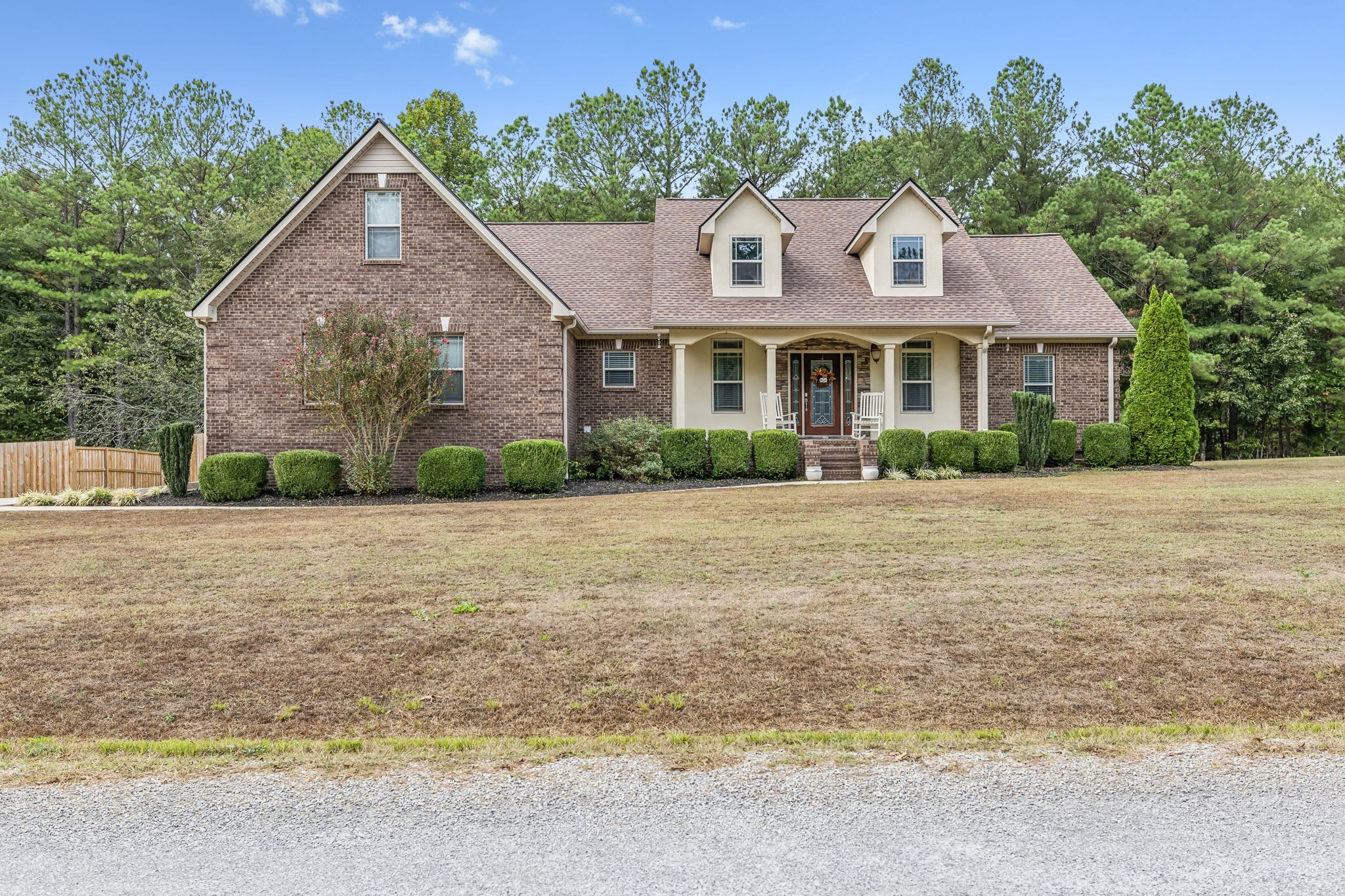 a front view of a house with a yard and trees