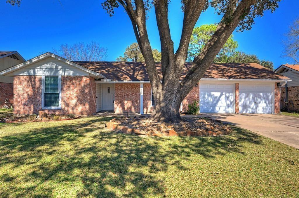 a view of a yard in front of a house with large tree