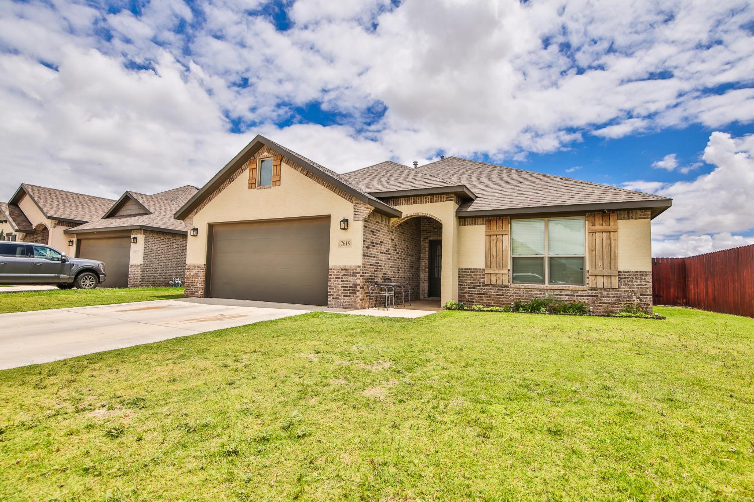 a front view of a house with a big yard and a garage