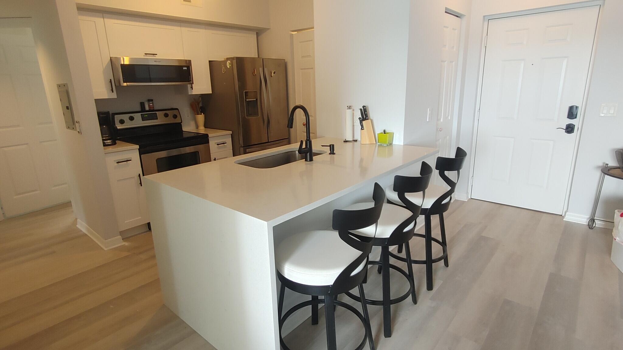 a kitchen with stainless steel appliances a refrigerator and microwave