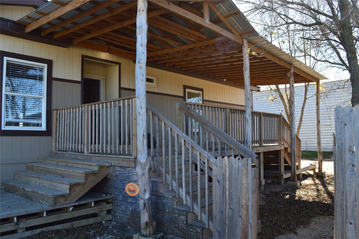 a view of backyard with wooden deck and a potted plant