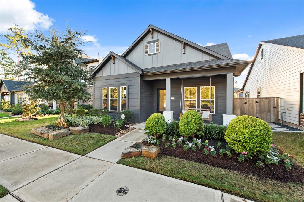 Beautiful landscaping with extended natural travertine front porch with swing.