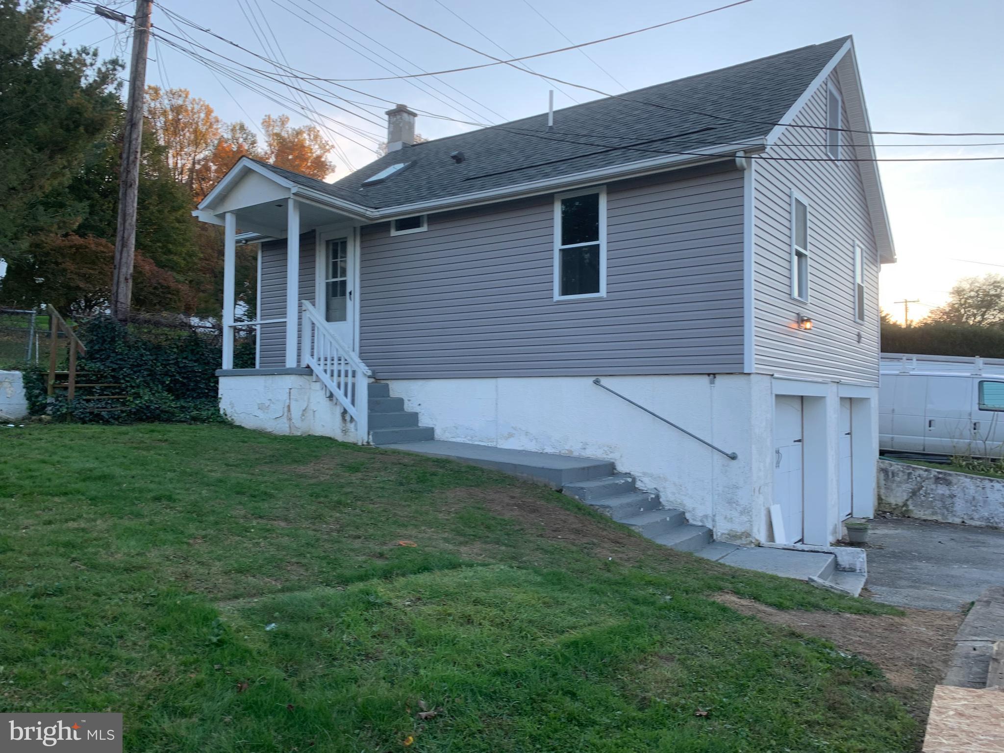 a view of a house with a yard and sitting area