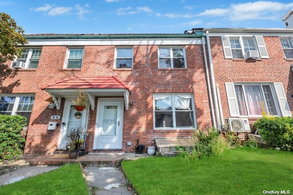 front view of a brick house with a yard