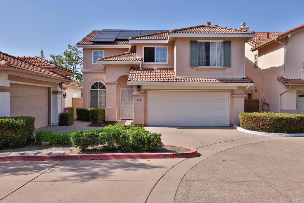 a front view of a house with a yard and a garage