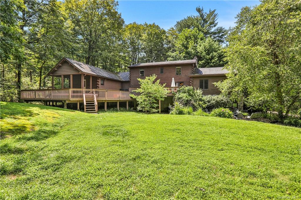 a view of a house with a big yard and large trees