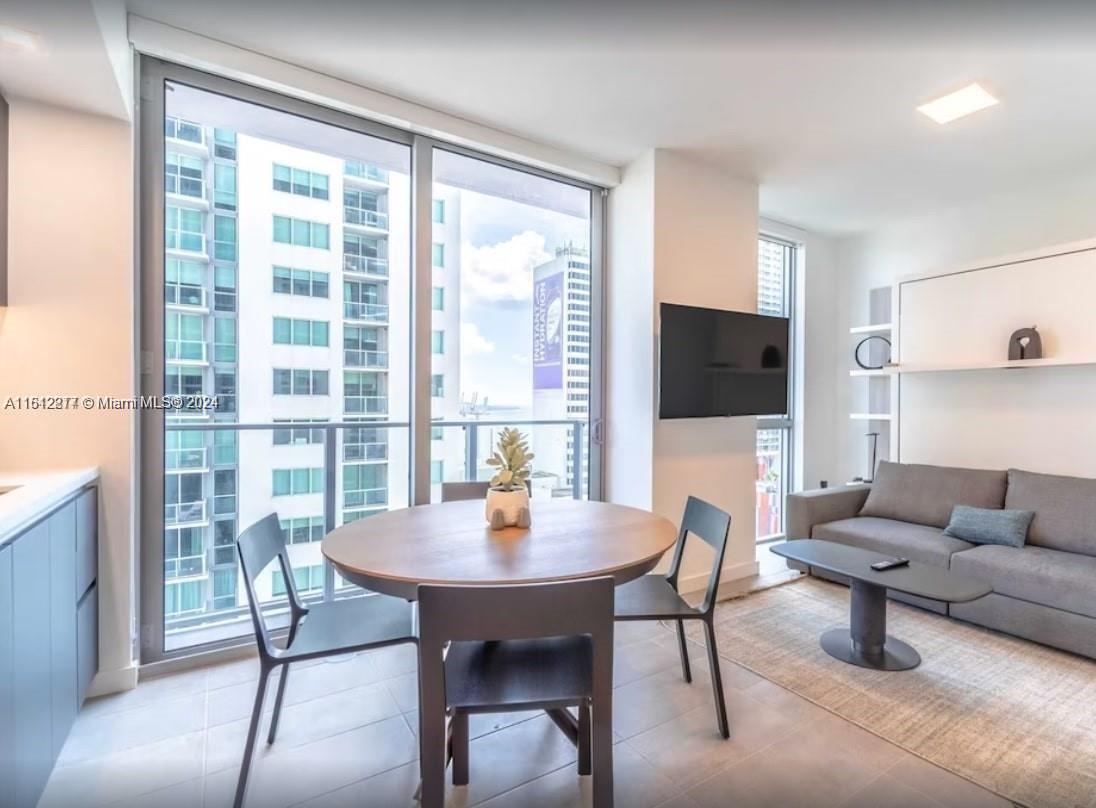 a dining room with furniture and a floor to ceiling window