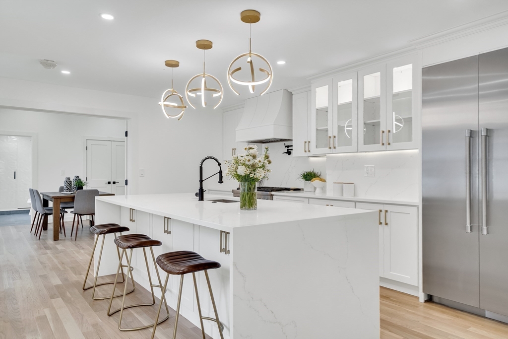 a kitchen with stainless steel appliances a table chairs and white cabinets