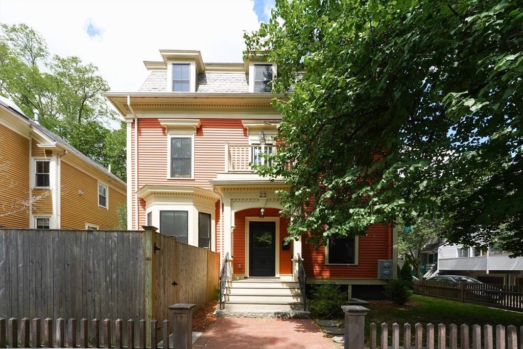 a front view of a house with a tree