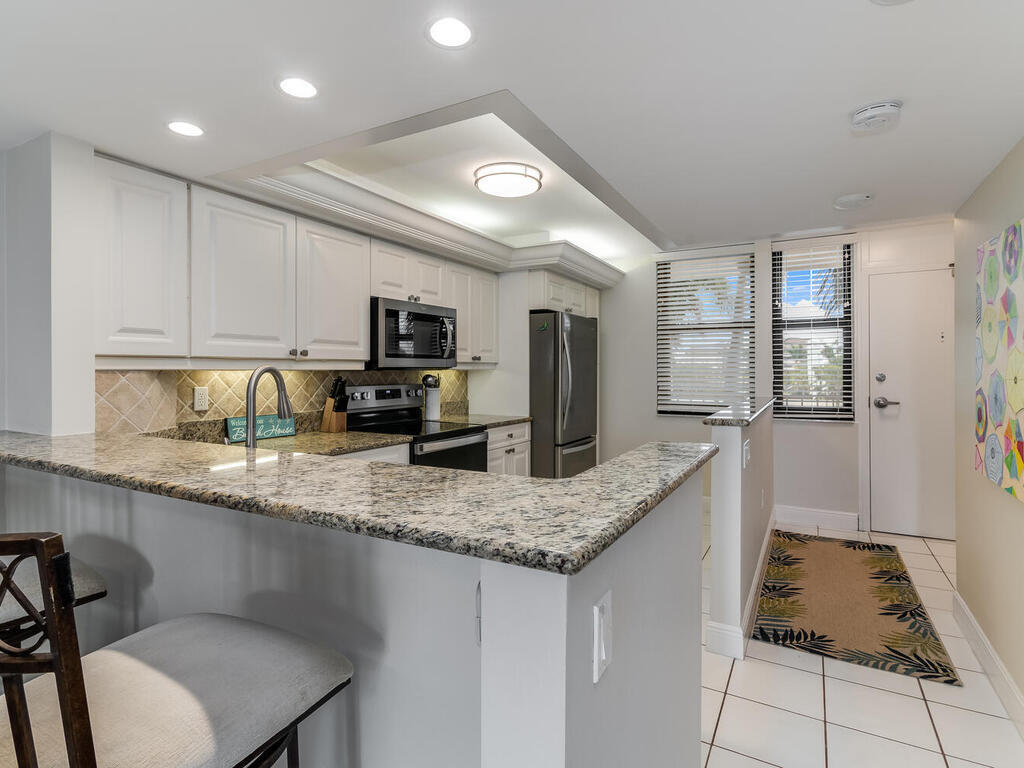 a kitchen with stainless steel appliances granite countertop a sink refrigerator and microwave