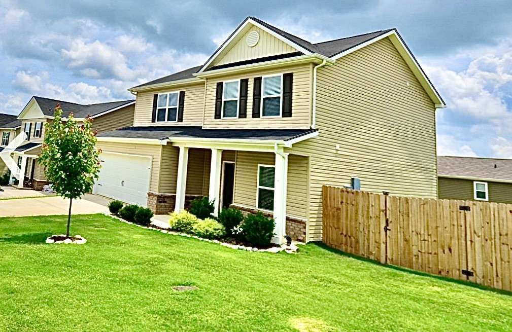 a view of a house with a yard and a garden