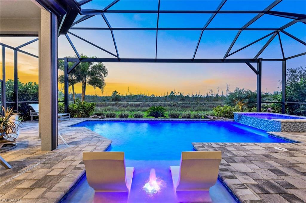 a view of swimming pool with a table and chairs under an umbrella