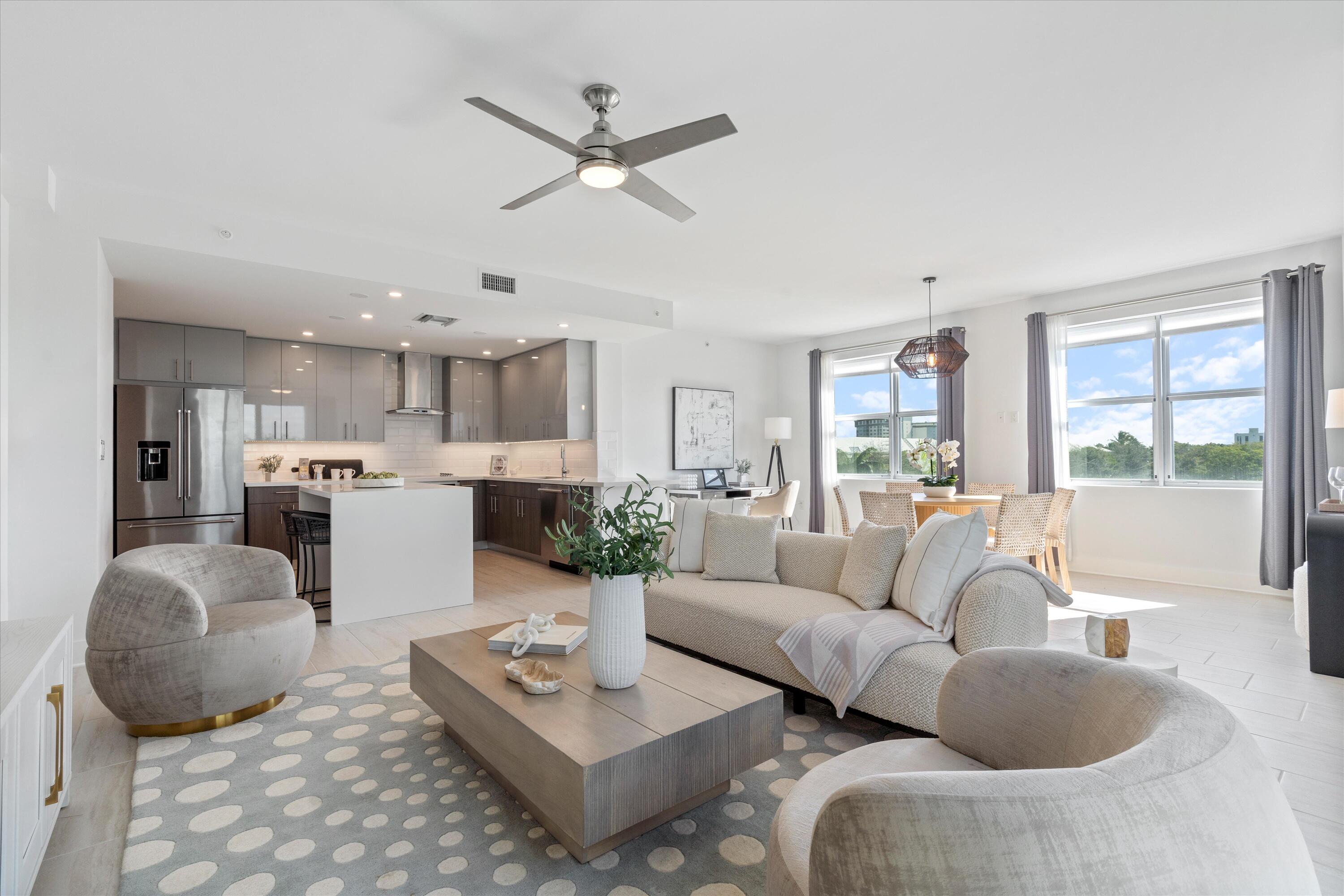 a living room with furniture kitchen view and a large window