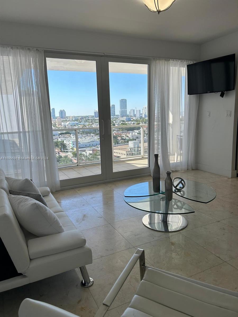 a living room with furniture and a floor to ceiling window