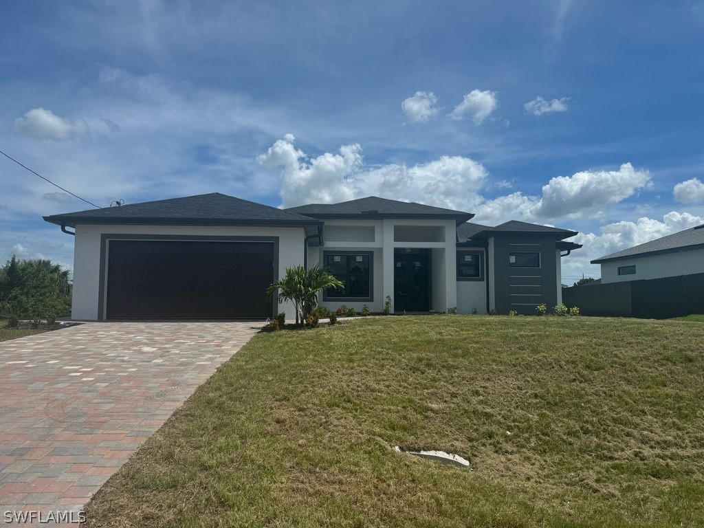 a front view of a house with a yard and a garage