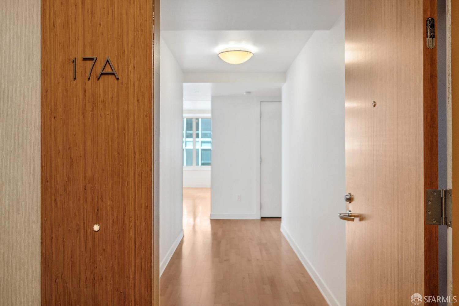 a view of a hallway with wooden floor