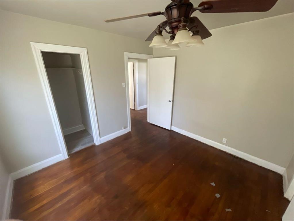 en empty room with wooden floor and windows