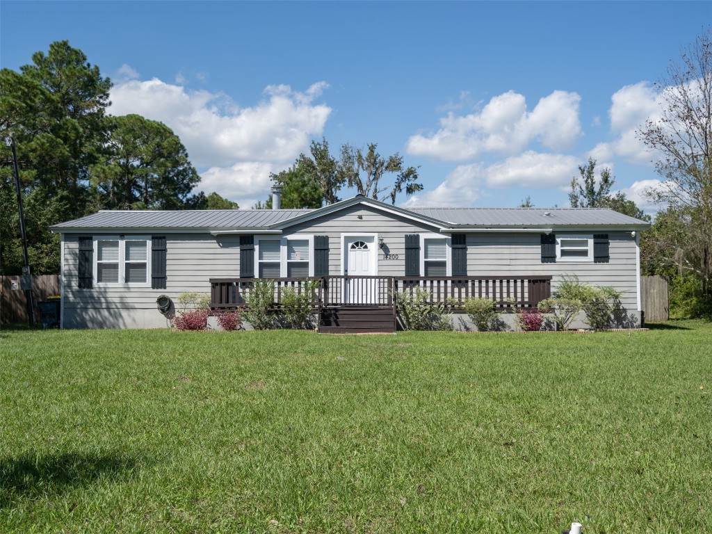 a view of a house with a yard and porch