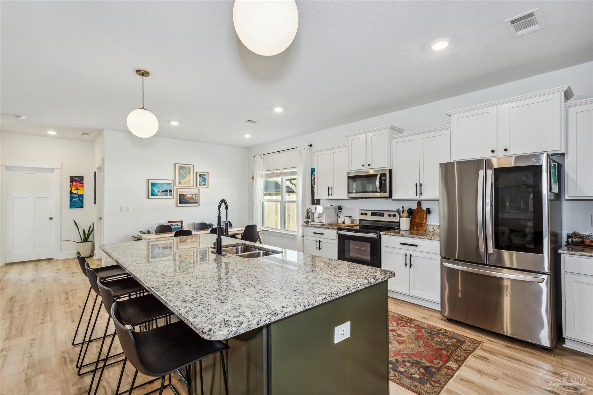 a kitchen with granite countertop kitchen island a counter space and stainless steel appliances