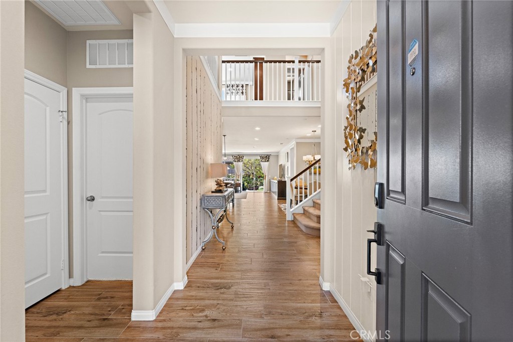 a view of a hallway with wooden floor and staircase