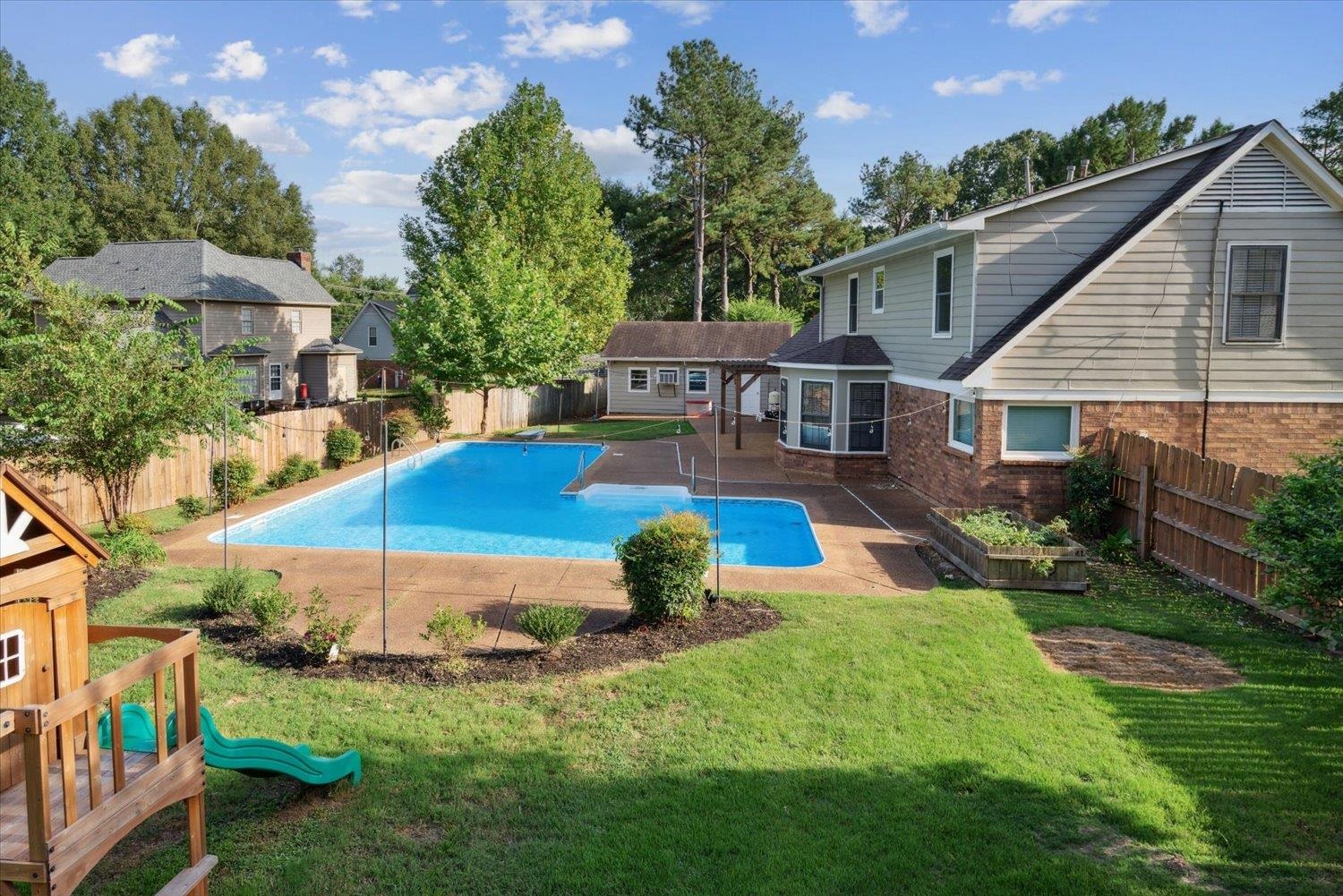 a view of a house with pool and a yard