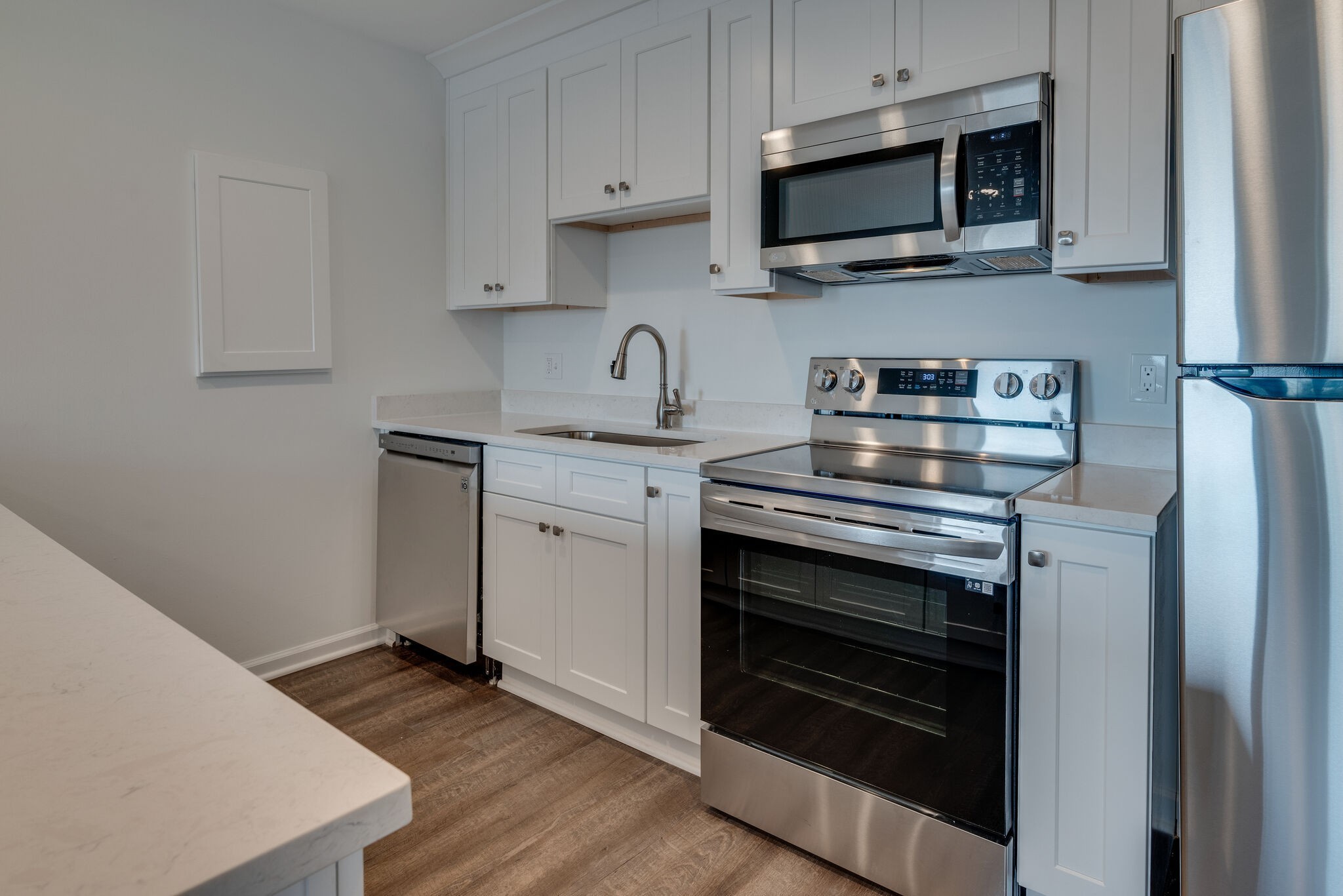 a kitchen with stainless steel appliances a stove microwave and sink