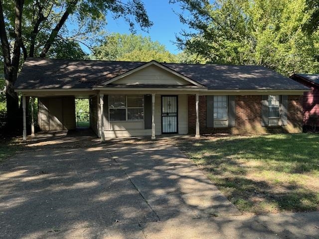 Single story home featuring a front lawn and a carport