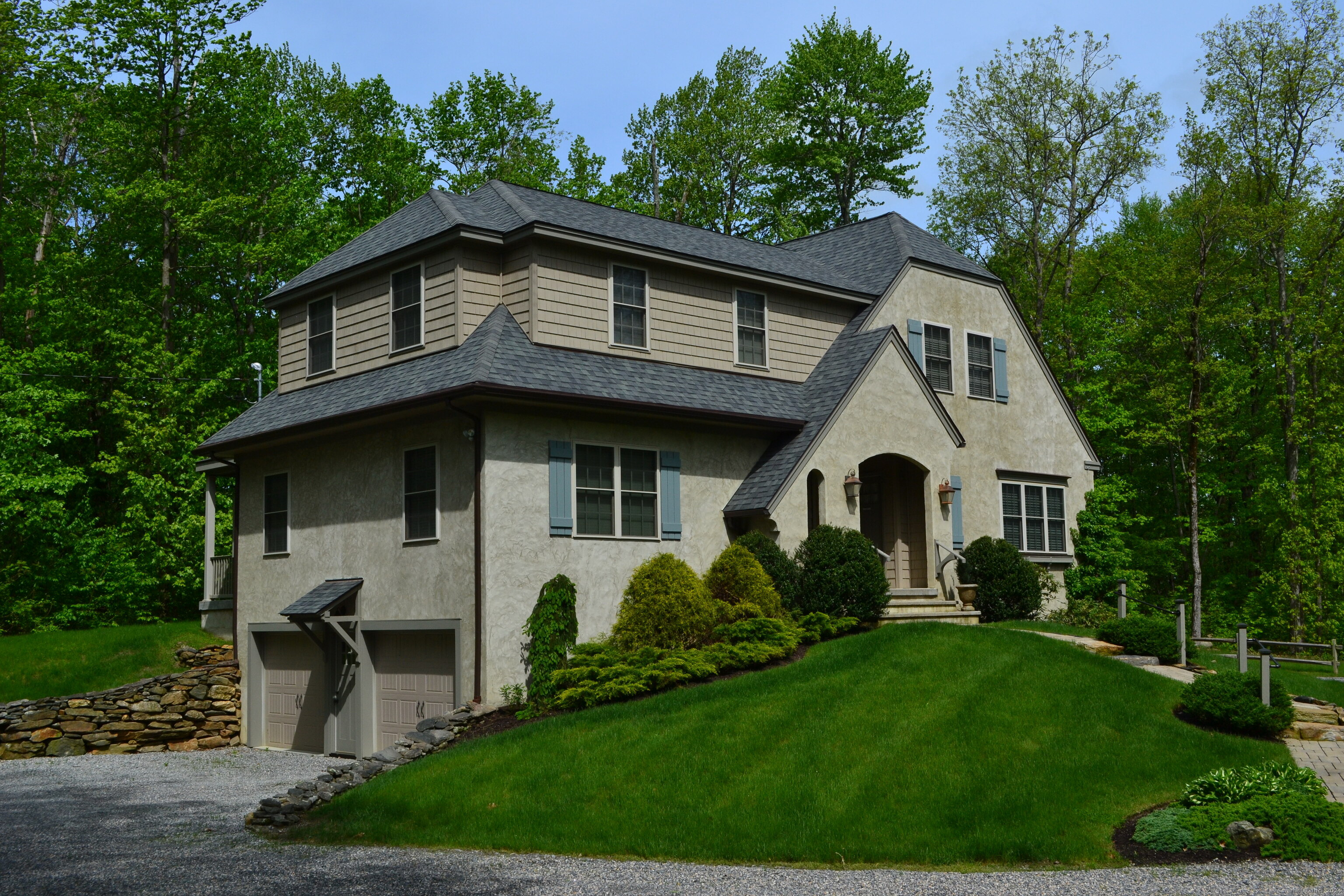 a front view of a house with a garden and plants