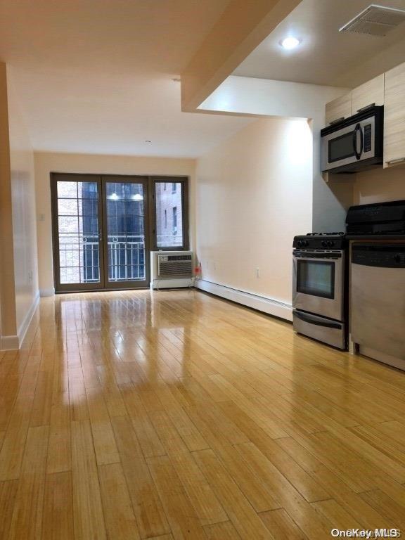 a view of empty room with wooden floor and fireplace