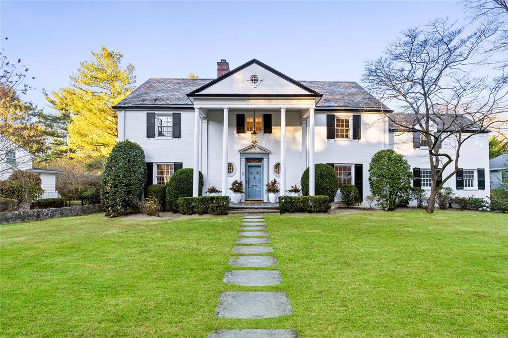 Greek revival inspired property featuring a front yard