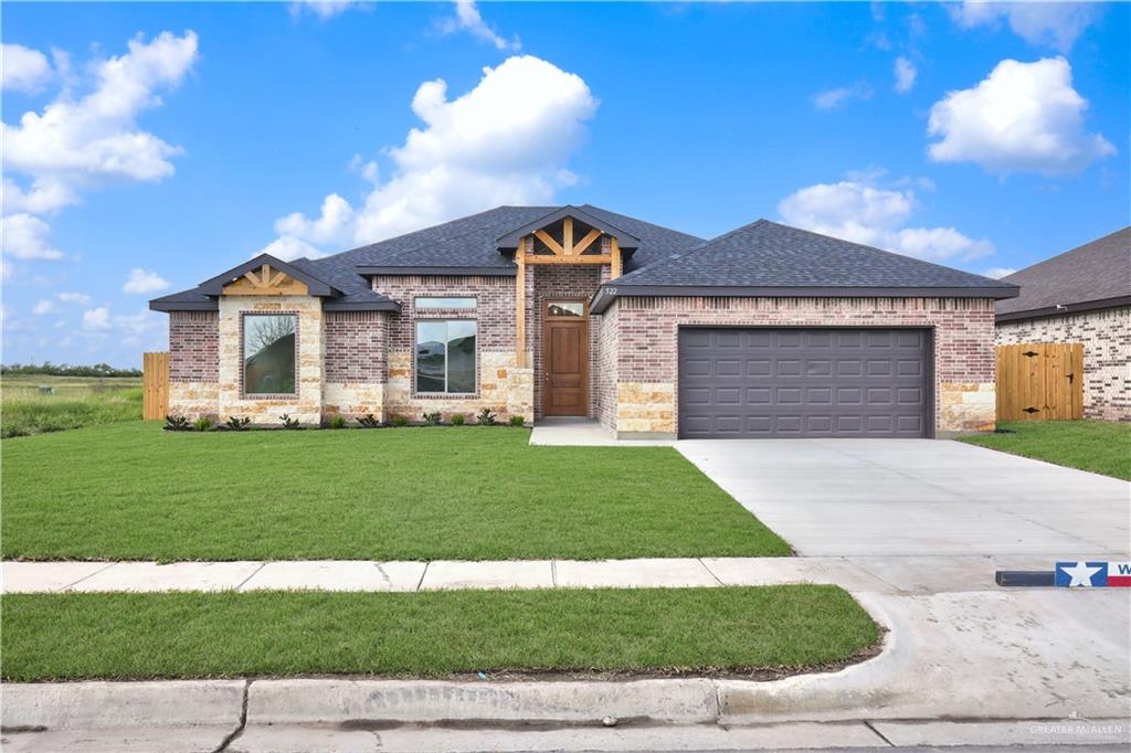 View of front of home with a front yard and a garage