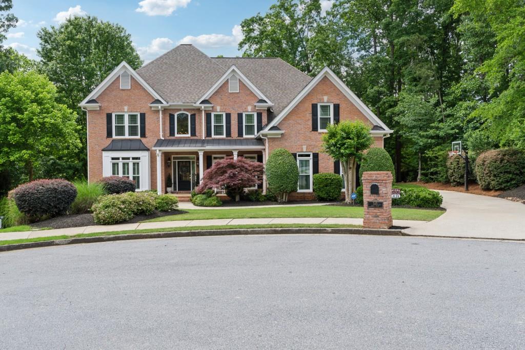 a front view of a house with a yard and trees