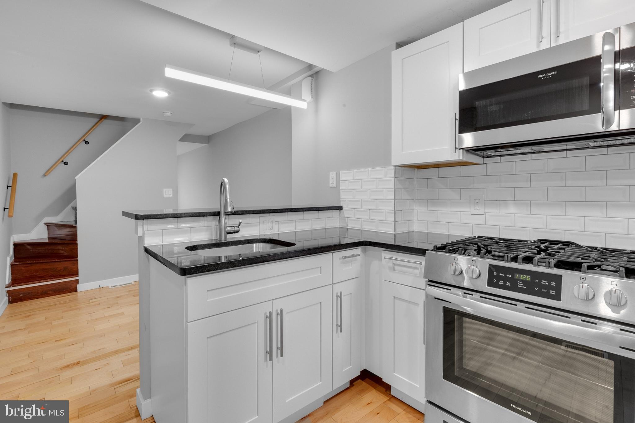 a kitchen with granite countertop a sink stainless steel appliances and cabinets