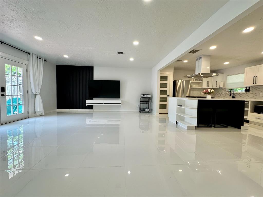 a view of kitchen with stainless steel appliances kitchen island a large counter top a stove and a sink