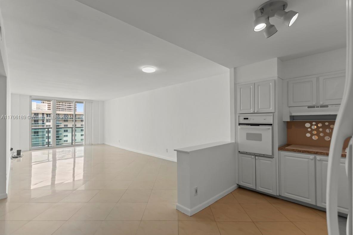 a kitchen with white cabinets and refrigerator