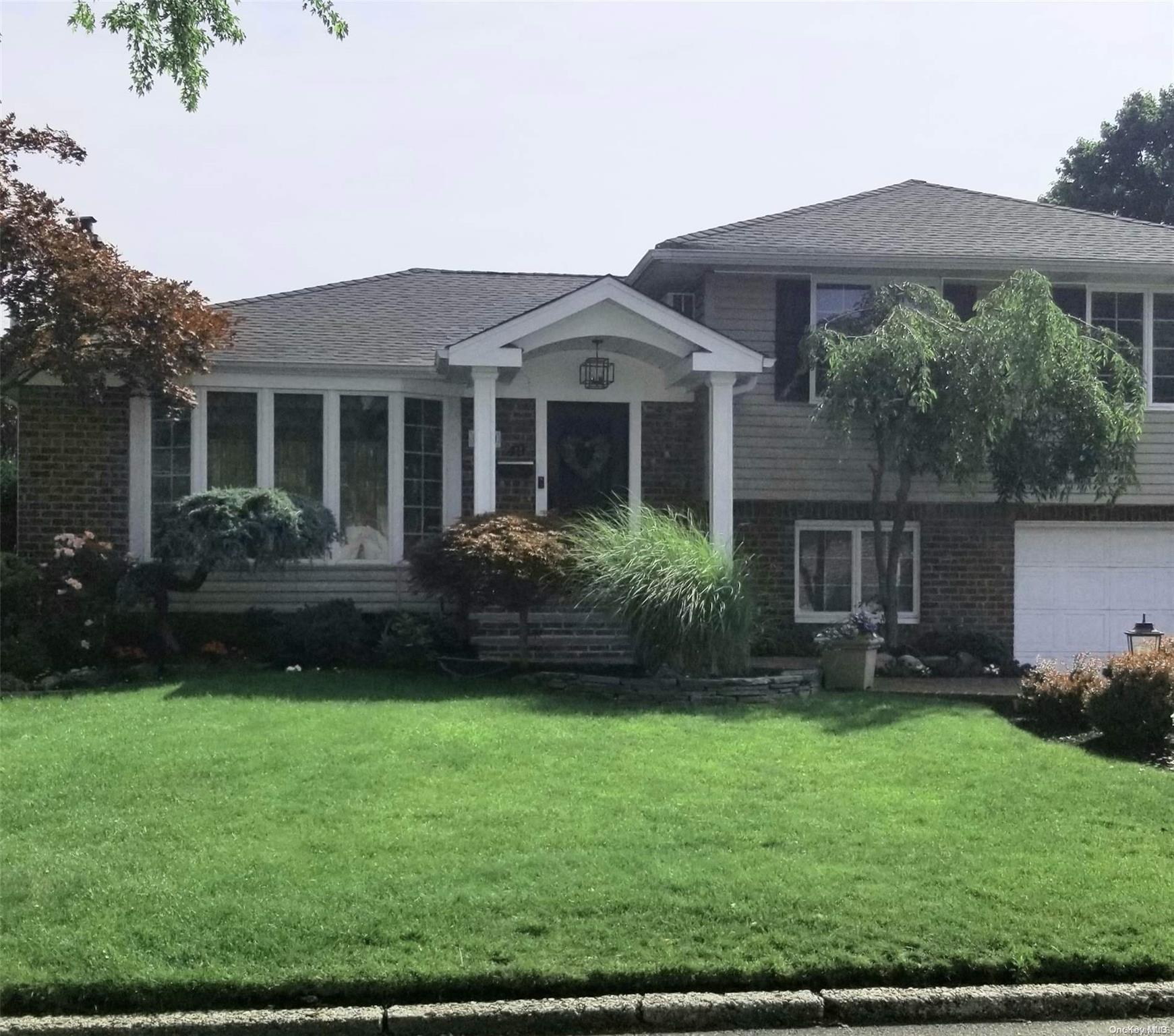 a front view of a house with a garden and yard