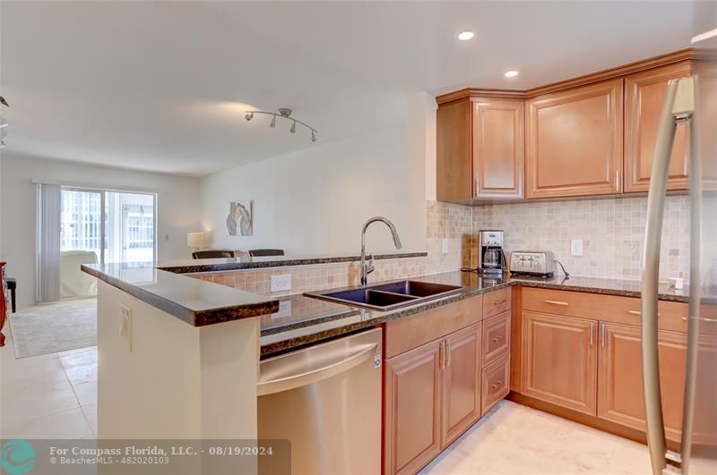 a kitchen with stainless steel appliances granite countertop a sink stove and cabinets